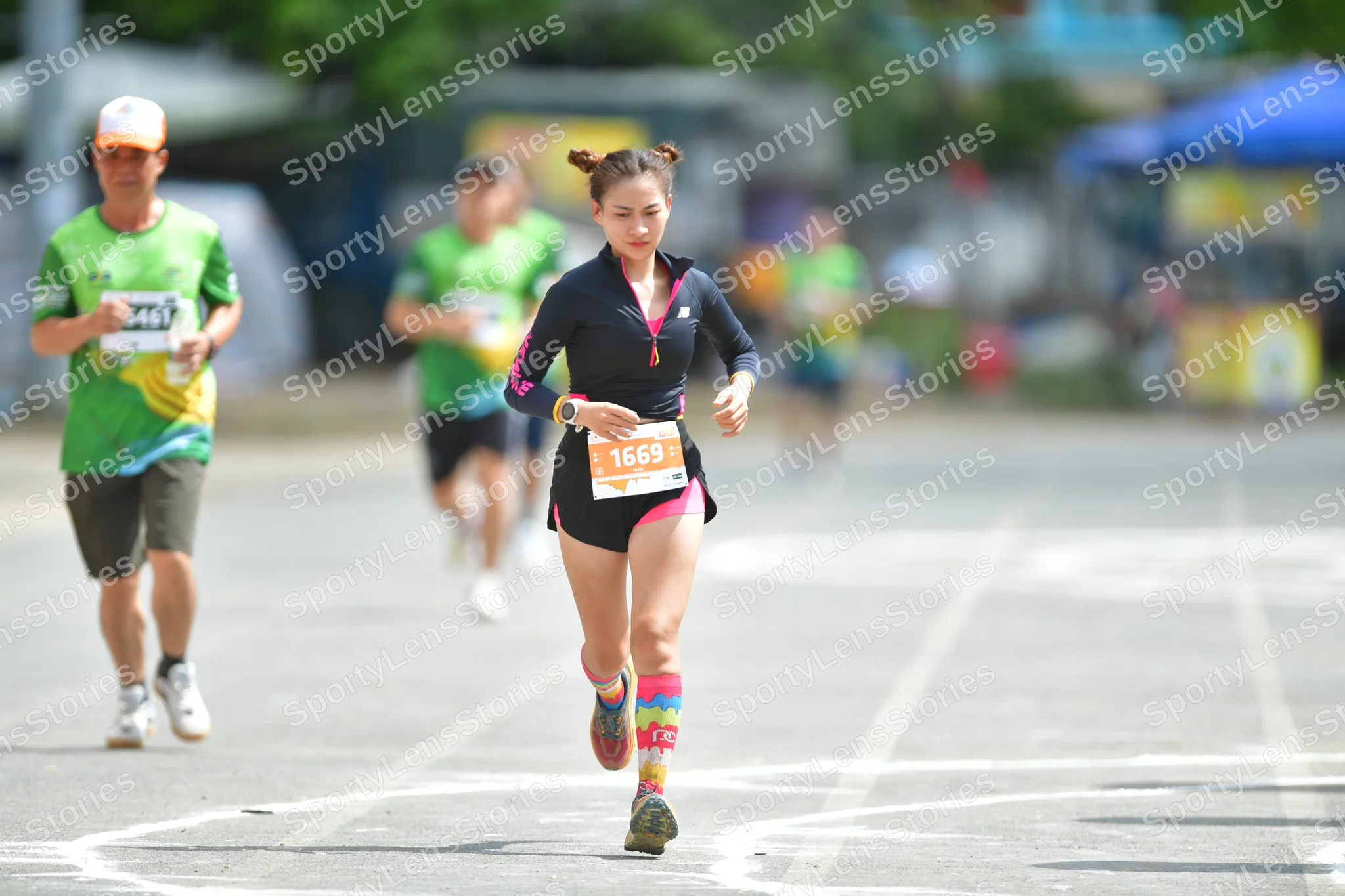 Marathon runner #1668, #1661: Runner 1: black long-sleeved top, black shorts, colorful tall socks, dark shoes