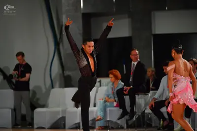Dancesport competitor: Male dancer: black long-sleeved Latin dance top with sequins and black trousers