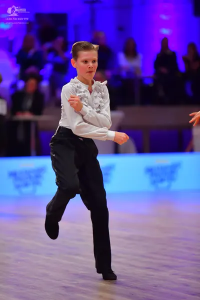 Dancesport competitor: Male dancer: white long-sleeved shirt with ruffles on the front, black trousers,