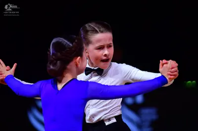 Dancesport competitor: Female dancer: royal blue long-sleeved dress in a smooth, solid-colored fabric