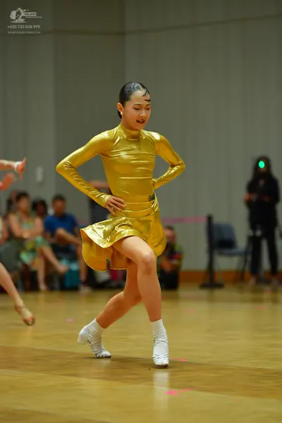 Dancesport competitor: Female dancer: gold metallic long-sleeved latin dress with a high neck and short