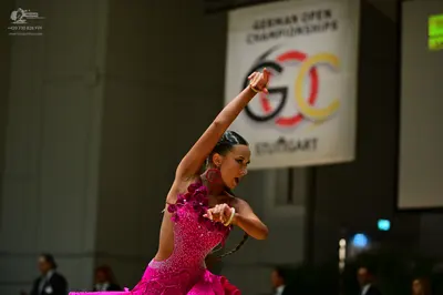 Dancesport competitor: Female dancer: magenta pink latin dance dress, heavily embellished with sequins 