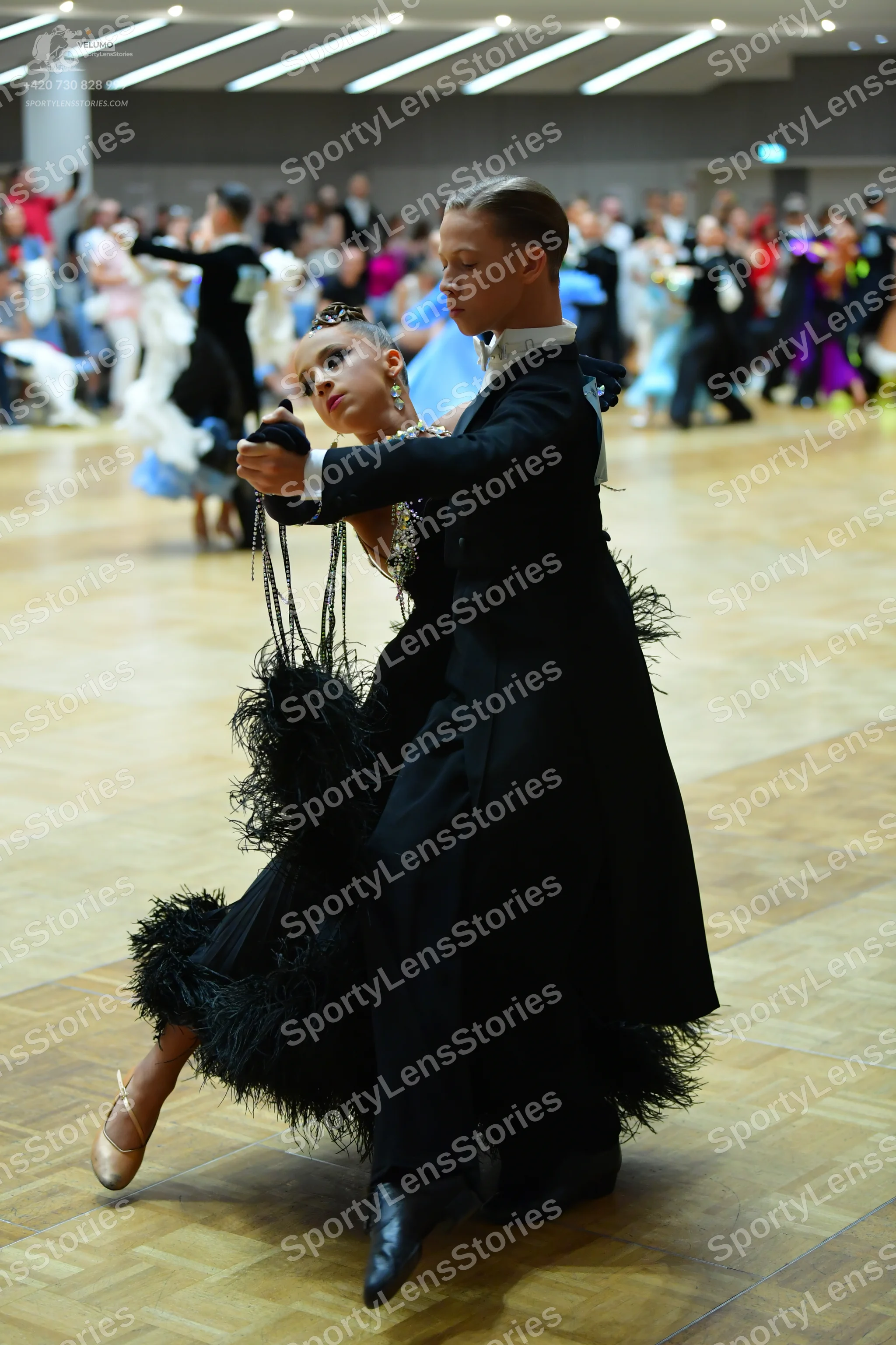 Dancesport competitor: Male dancer: black ballroom tailcoat, white shirt collar, black trousers, and bl