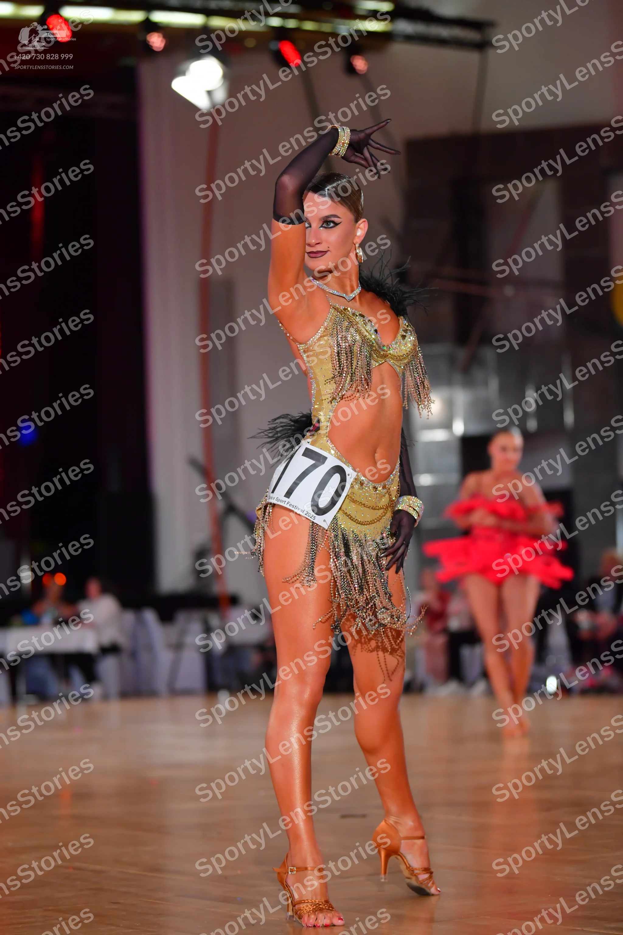 Dancesport competitor #170: Female dancer 1: gold latin dress with sequins and long fringe, and black sheer 