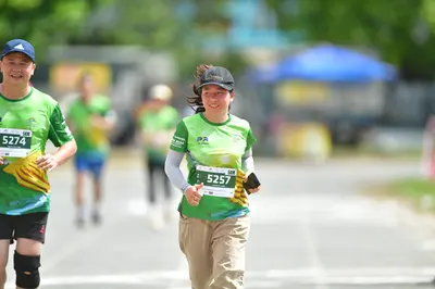 Marathon runner #5274, #5257: Runner 1: green and yellow jersey, black shorts, blue cap, black compression sle