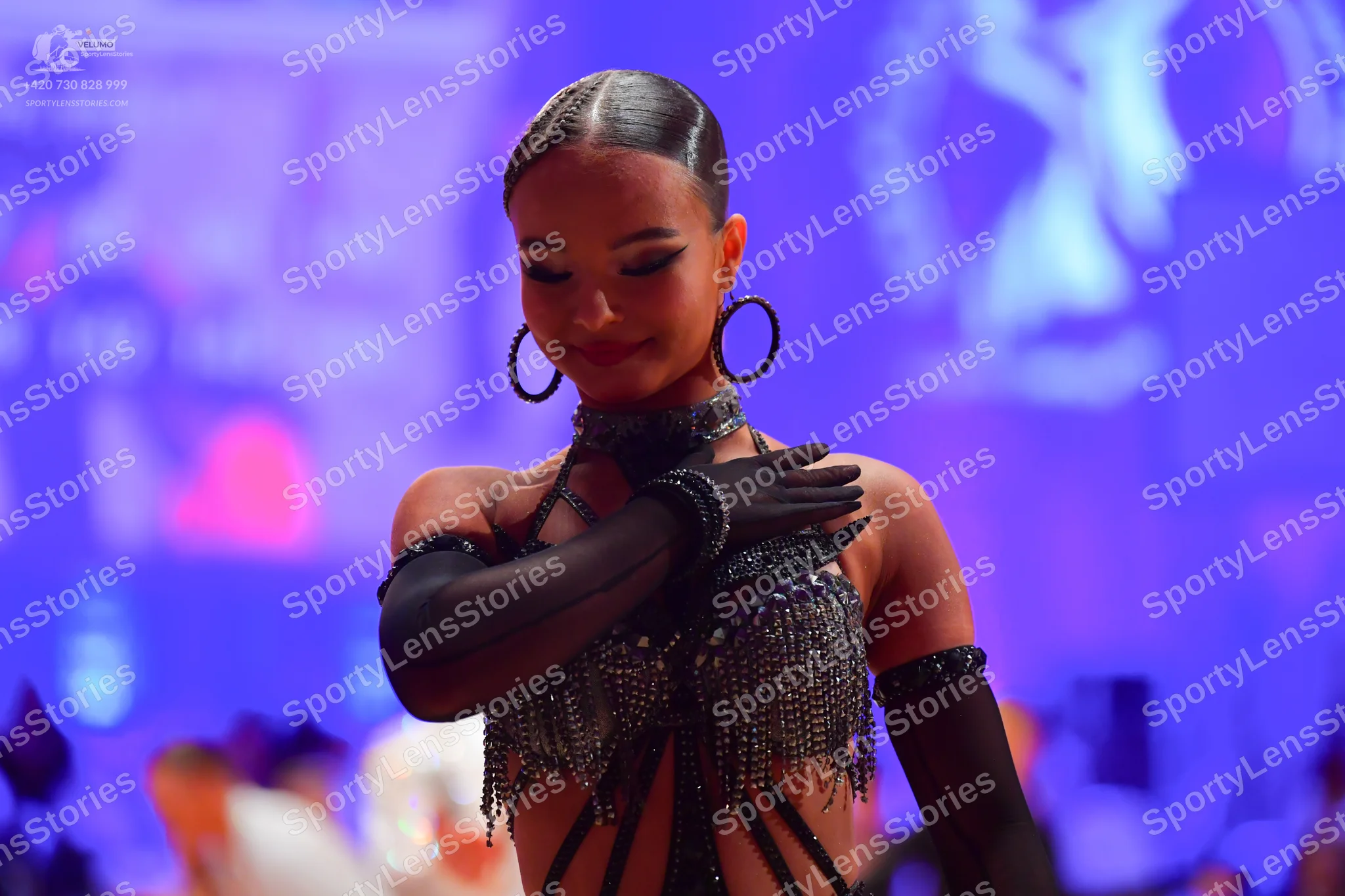 Dancesport competitor: Female dancer: black Latin-style costume featuring heavy bead and sequin fringe,
