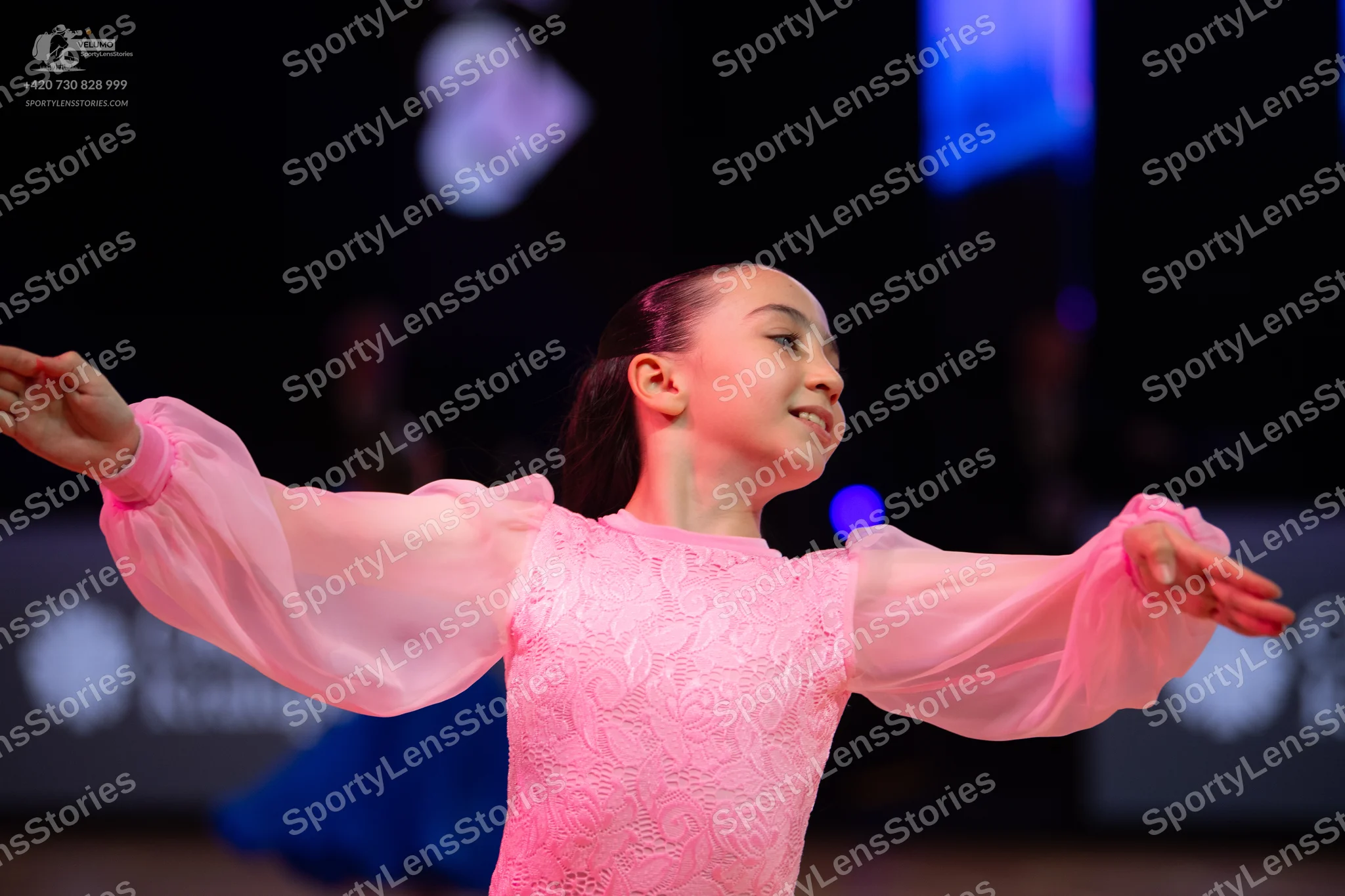 Dancesport competitor: Female dancer: light pink ballroom dress with a lace bodice and sheer, voluminou