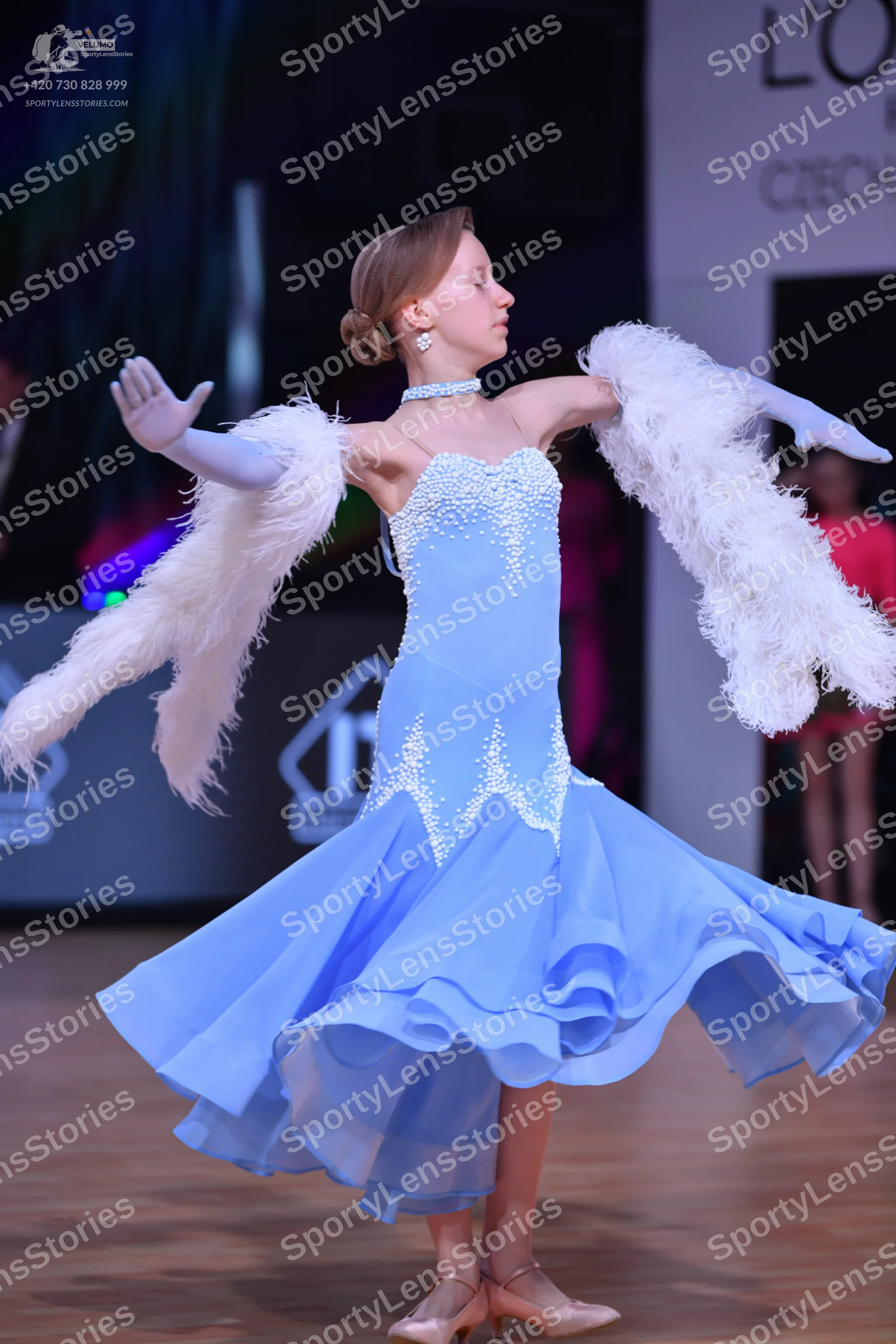 Dancesport competitor: Female dancer: light blue ballroom gown with rhinestone/bead embellishments on t