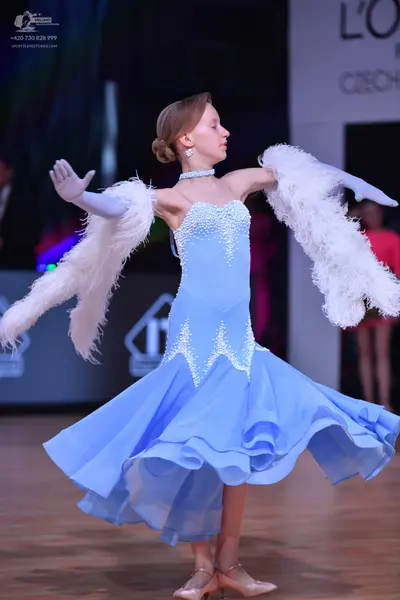 Dancesport competitor: Female dancer: light blue ballroom gown with rhinestone/bead embellishments on t