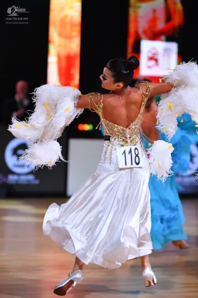Dancesport competitor: Female dancer: white ballgown with a gold sequined bodice and a voluminous white