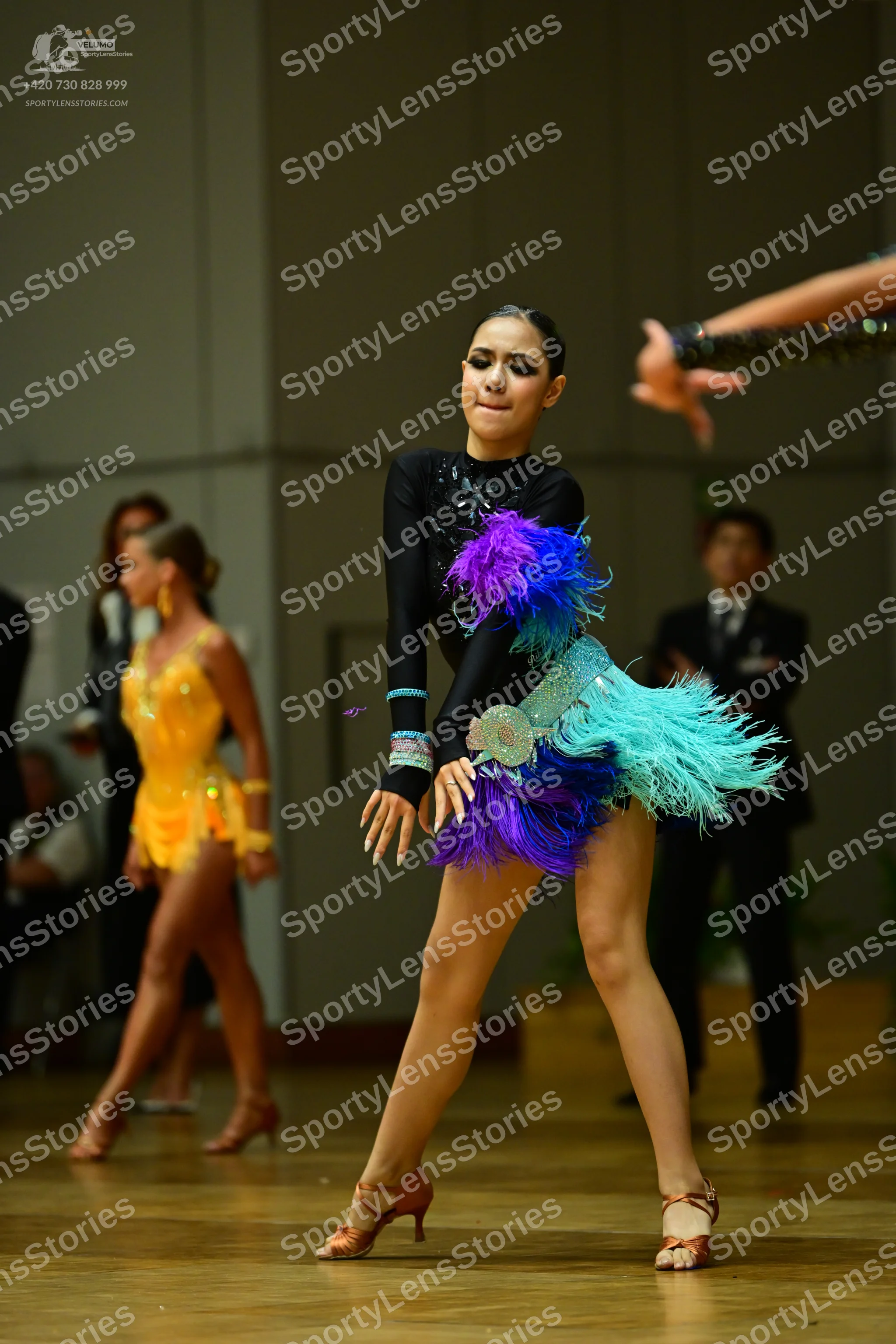 Dancesport competitor: Female dancer 1: black long-sleeved latin dress with a colorful purple, blue, an