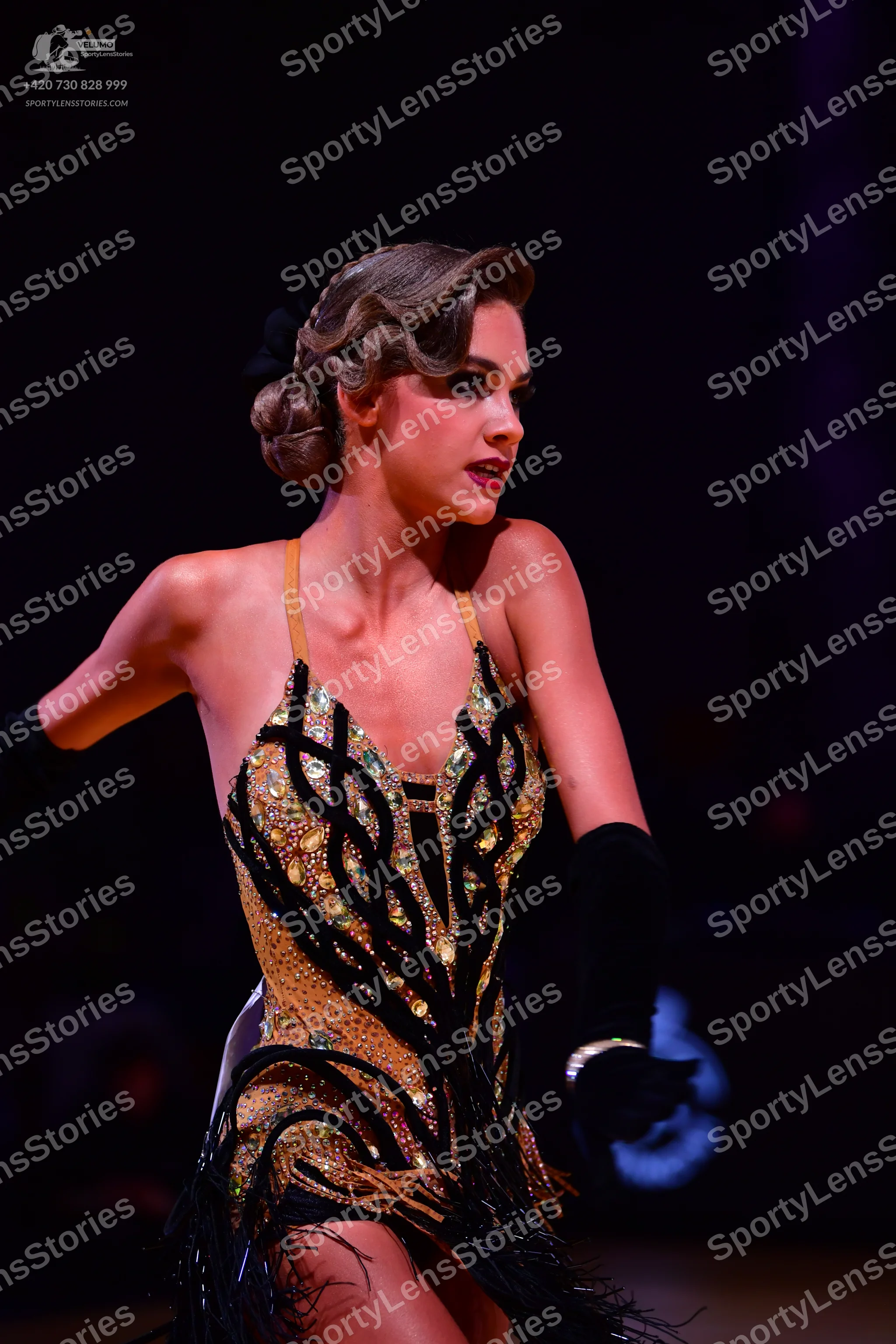 Dancesport competitor: Female dancer: black and gold Latin dance dress with intricate sequin and crysta