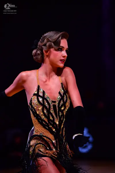 Dancesport competitor: Female dancer: black and gold Latin dance dress with intricate sequin and crysta