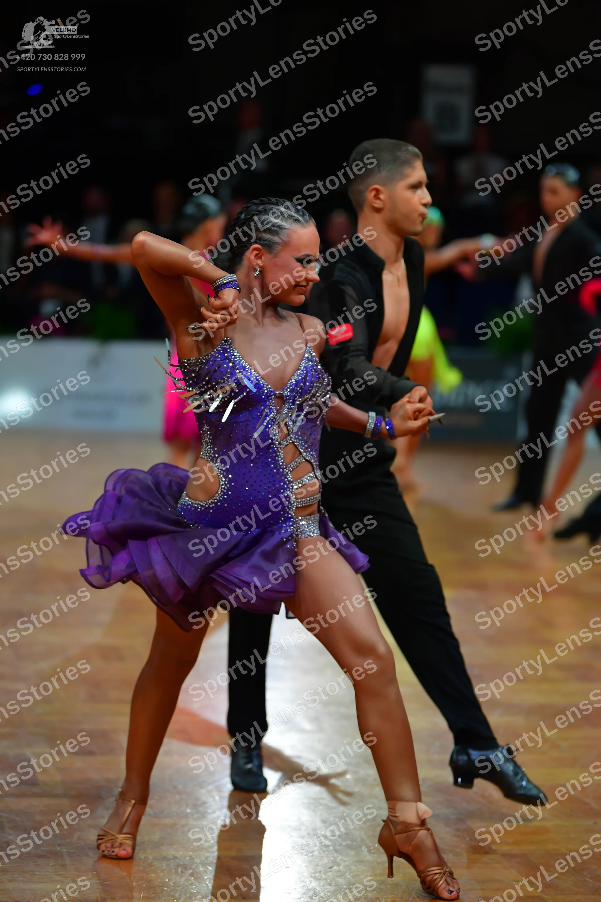 Dancesport competitor: Female dancer: purple Latin dance dress with sequins, mesh panels, and silver ac
