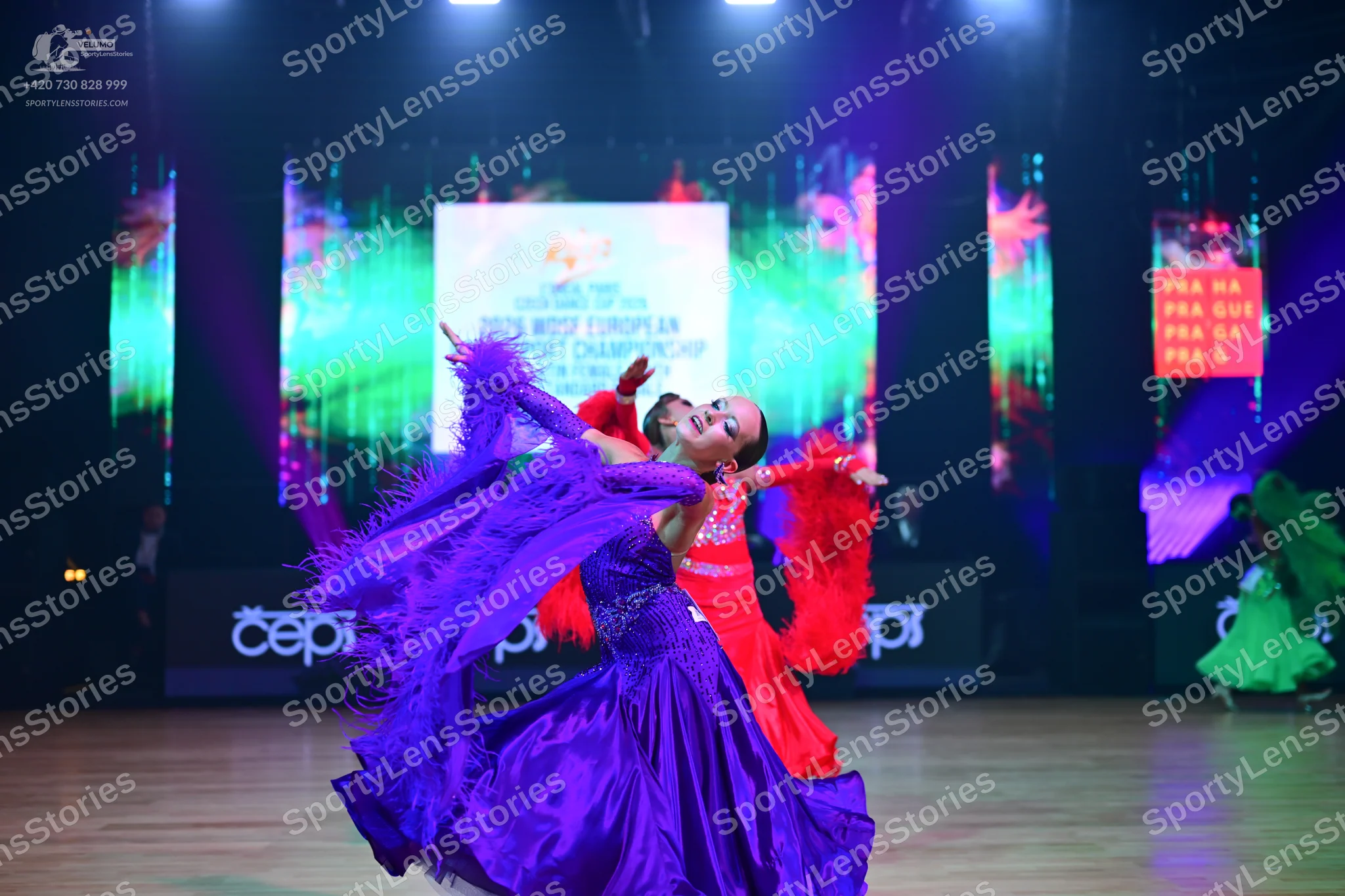 Dancesport competitor: Female dancer: large, voluminous purple ballroom gown with a shiny, satin-like f