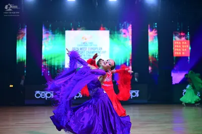 Dancesport competitor: Female dancer: large, voluminous purple ballroom gown with a shiny, satin-like f