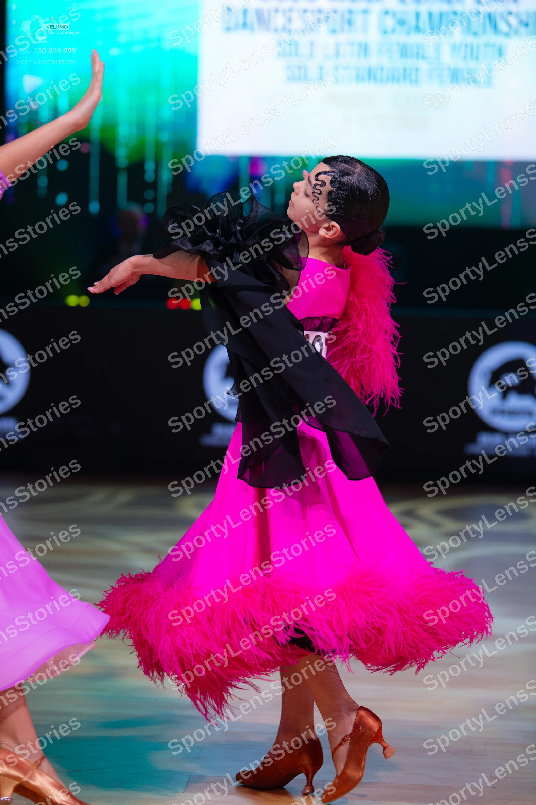 Dancesport competitor: Female dancer 1: bright pink latin dress with a voluminous pink feather trim at