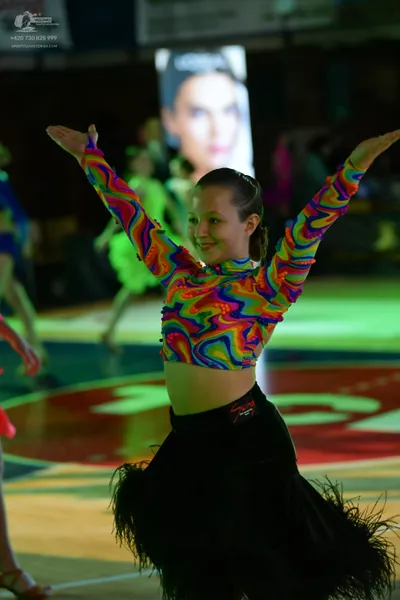 Dancesport competitor: Female dancer: colorful psychedelic-patterned long-sleeved crop top with vibrant