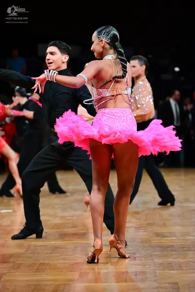 Dancesport competitor: Female dancer: pink latin dance costume with a sequined bodice and a voluminous 