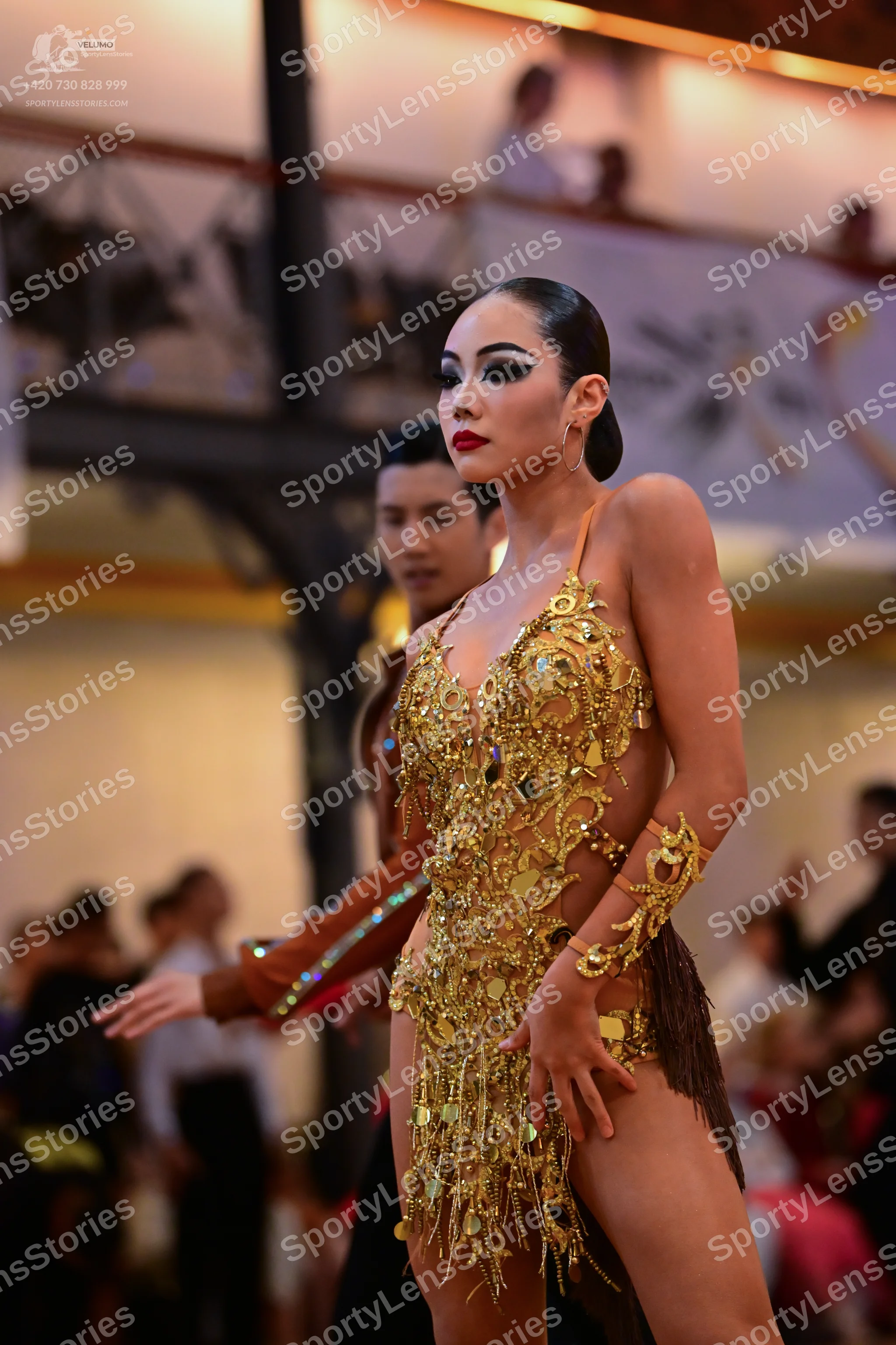 Dancesport competitor: Female dancer: gold Latin dress with heavy sequin and crystal embellishments, fe
