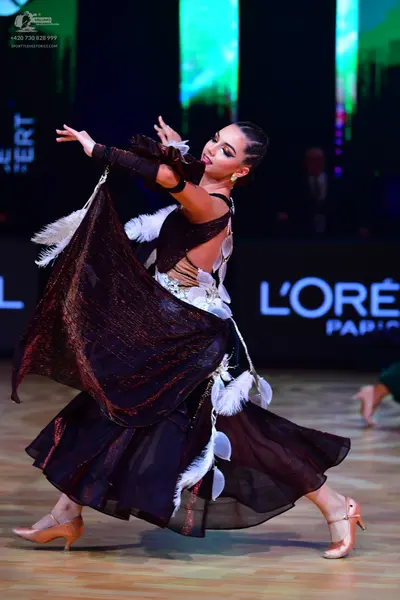 Dancesport competitor: Female dancer: black dance dress with white feathered or fringed trim