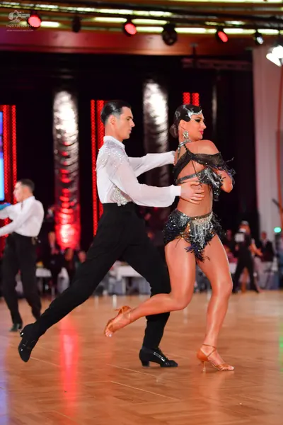 Dancesport competitor: Male dancer: white long-sleeved shirt with silver sequin embellishments on the c