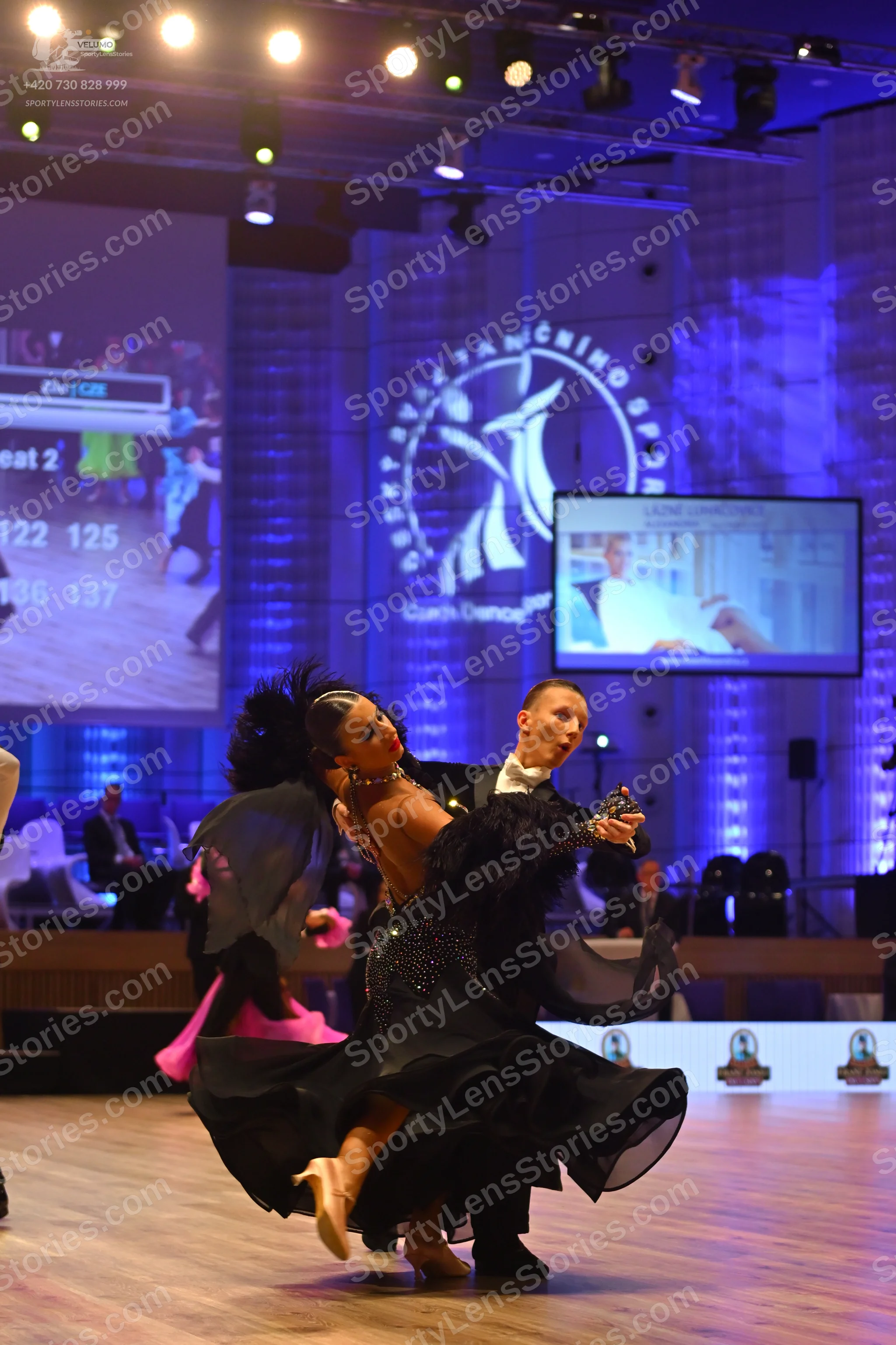 Dancesport competitor: Female dancer: black ballgown with a voluminous, flowing skirt and black feather