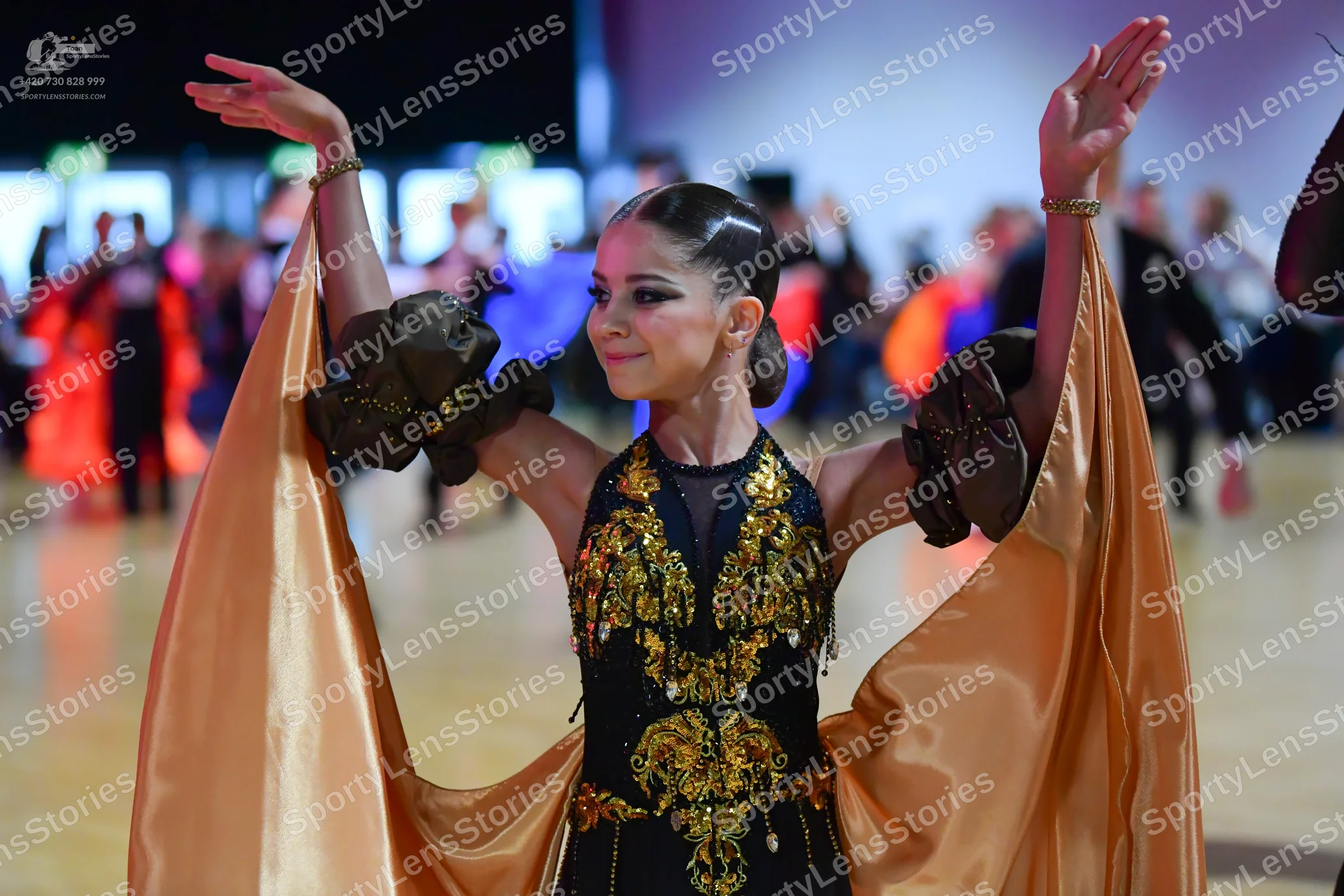 Dancesport competitor: Female dancer: A black dress featuring intricate gold, yellow, and green sequin