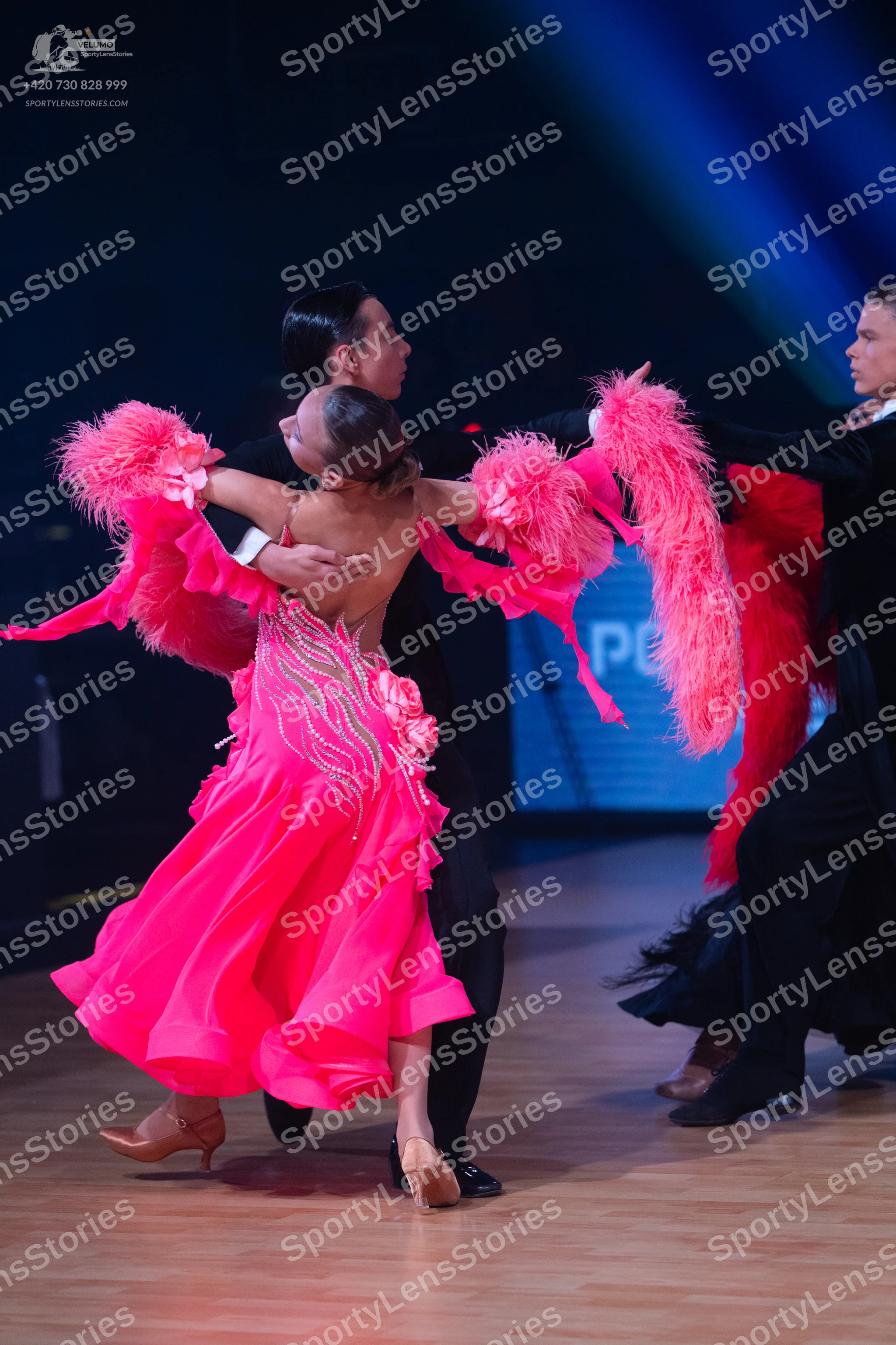 Dancesport competitor: Female dancer: bright pink Latin dance dress with large pink feather-like fringe