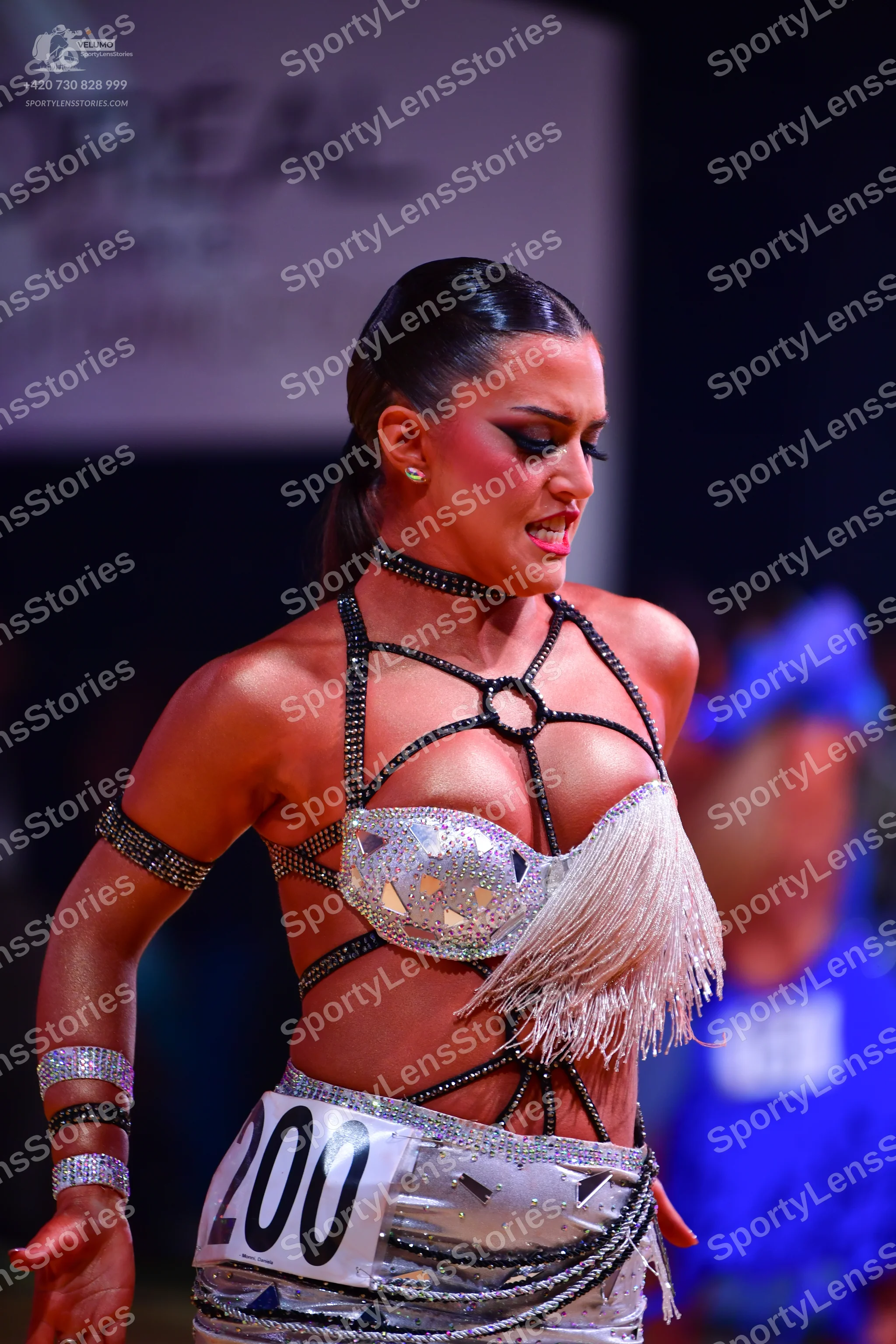 Dancesport competitor: Female dancer: silver and white latin dress decorated with numerous sequins and 