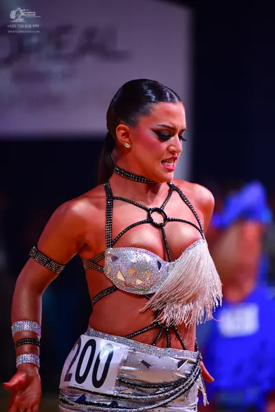 Dancesport competitor: Female dancer: silver and white latin dress decorated with numerous sequins and 