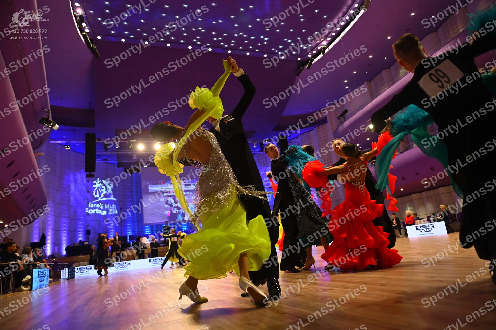 Dancesport competitor: Female dancer (foreground): lime green/yellow latin dress with fringe and sequin