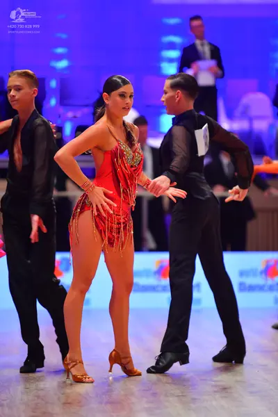 Dancesport competitor: Male dancer (left): black latin-style shirt and black trousers