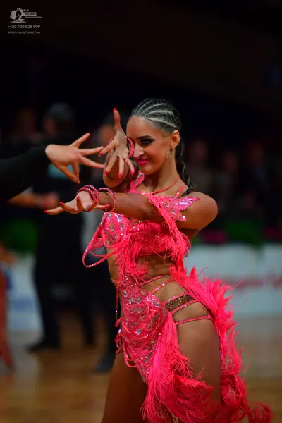 Dancesport competitor: Female dancer: bright pink Latin dress with sequins and long pink feather fringe