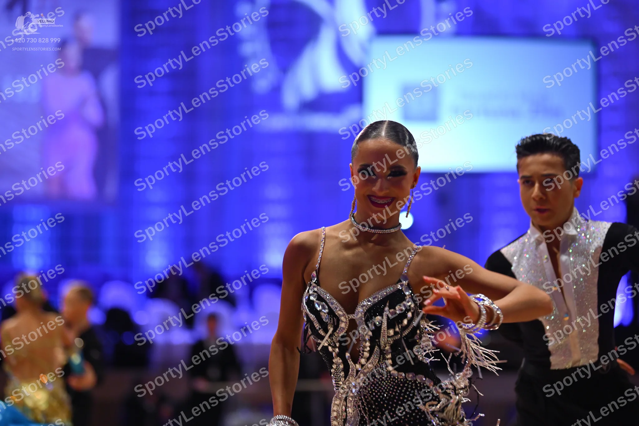 Dancesport competitor: Male dancer: white Latin dance shirt with a large sequined collar and black trou