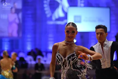 Dancesport competitor: Male dancer: white Latin dance shirt with a large sequined collar and black trou
