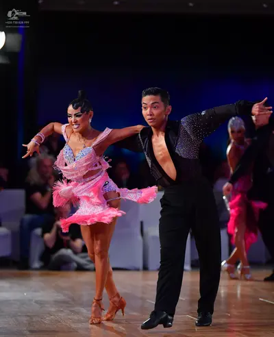 Dancesport competitor: Female dancer: pink sequined Latin dress with a frilled skirt