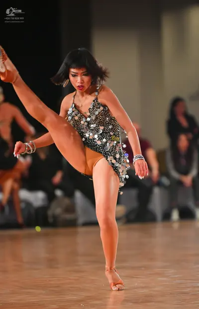 Dancesport competitor: Female dancer: black Latin dance dress heavily embellished with large, silver se