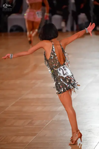 Dancesport competitor #25, #15: Foreground dancer: black latin dress with white polka dots and silver sequin emb