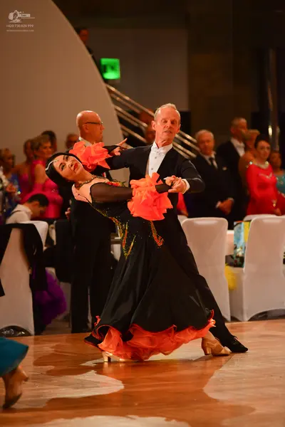 Dancesport competitor: Male dancer: black suit with a white shirt and a white bow tie