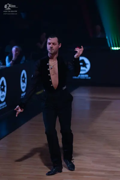 Dancesport competitor: Male dancer: black long-sleeved open-front shirt and black trousers
