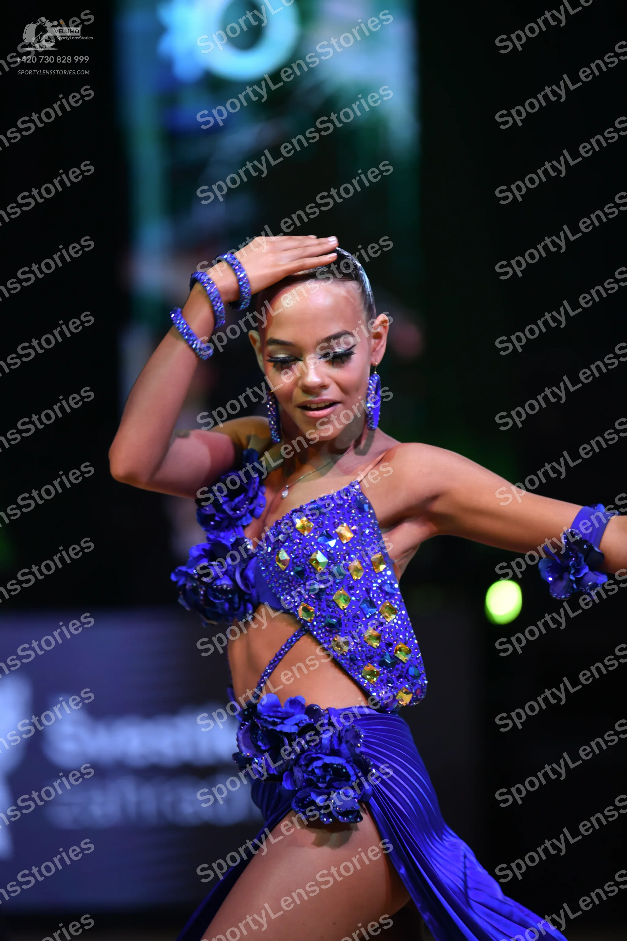 Dancesport competitor: Female dancer: bright blue Latin dance costume featuring a sequined crop top and