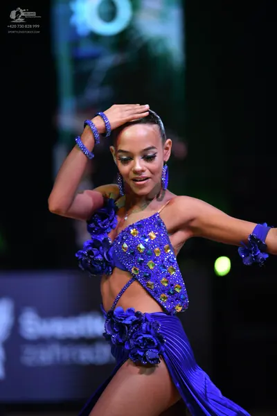 Dancesport competitor: Female dancer: bright blue Latin dance costume featuring a sequined crop top and