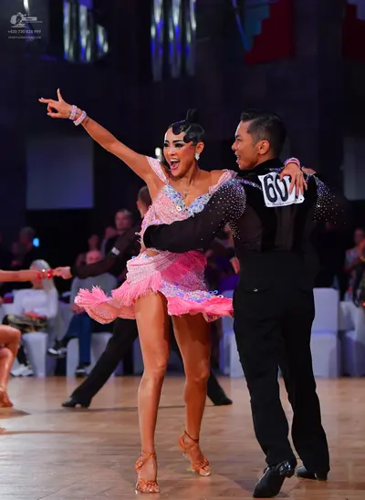 Dancesport competitor #60: Female dancer: pink latin dress with sequins and fringe, accessorized with earri
