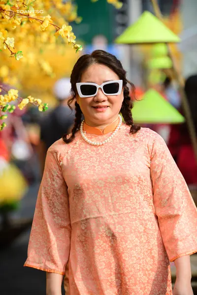 Dancesport competitor: Female dancer: peach-colored floral patterned top with long sleeves, wearing a w