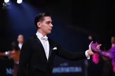 Dancesport competitor: Male dancer: black suit with a white shirt and a white bow tie