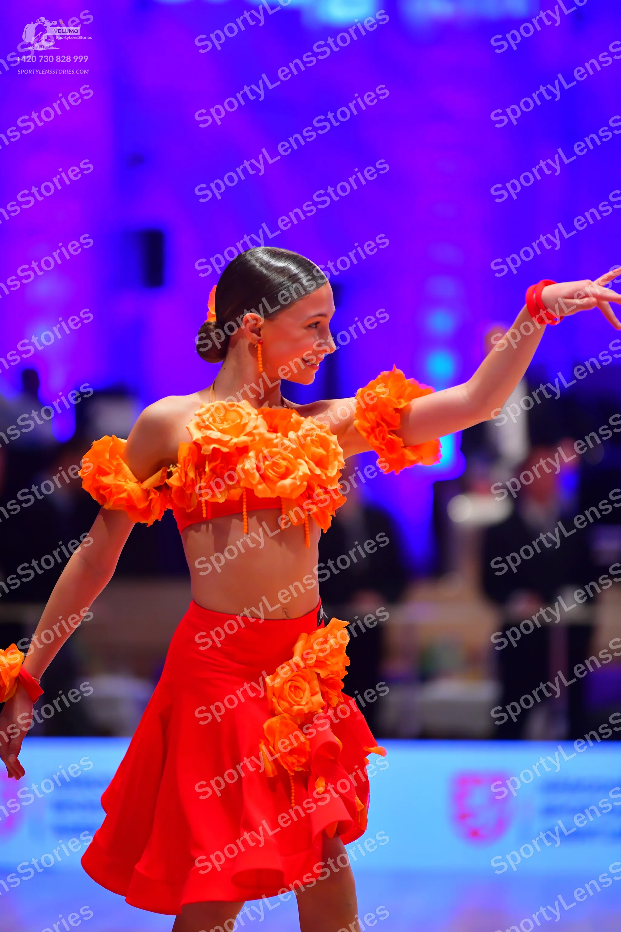 Dancesport competitor: Female dancer: two-piece red Latin costume consisting of a crop top and short sk