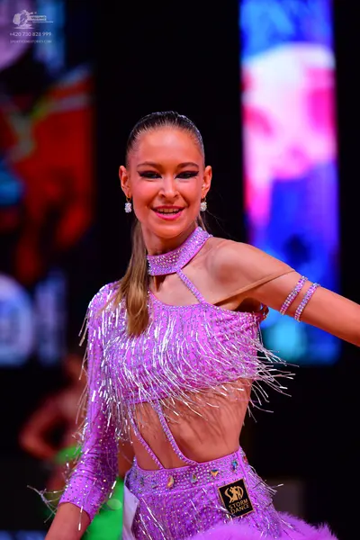 Dancesport competitor: Female dancer: lilac Latin dance dress with sequins, rhinestones, and long sleev