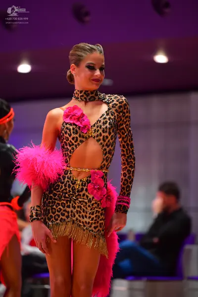 Dancesport competitor: Female dancer: leopard print Latin dress with long sleeves, cutouts, pink floral