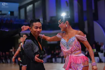Dancesport competitor: Male dancer: black long-sleeve shirt with silver sequins on the shoulders and ch